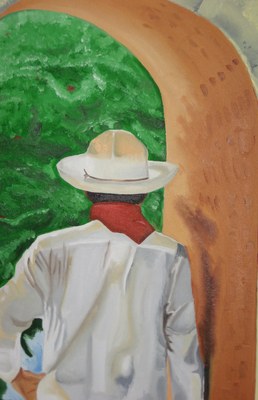 A man in a white shirt and straw hat seen from behind, against green foliage and a terracotta arch
