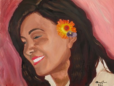 A woman with long dark hair smiles with her eyes closed, head tilted, an orange flower and a small purple one tucked behind her ear, against a pink ground